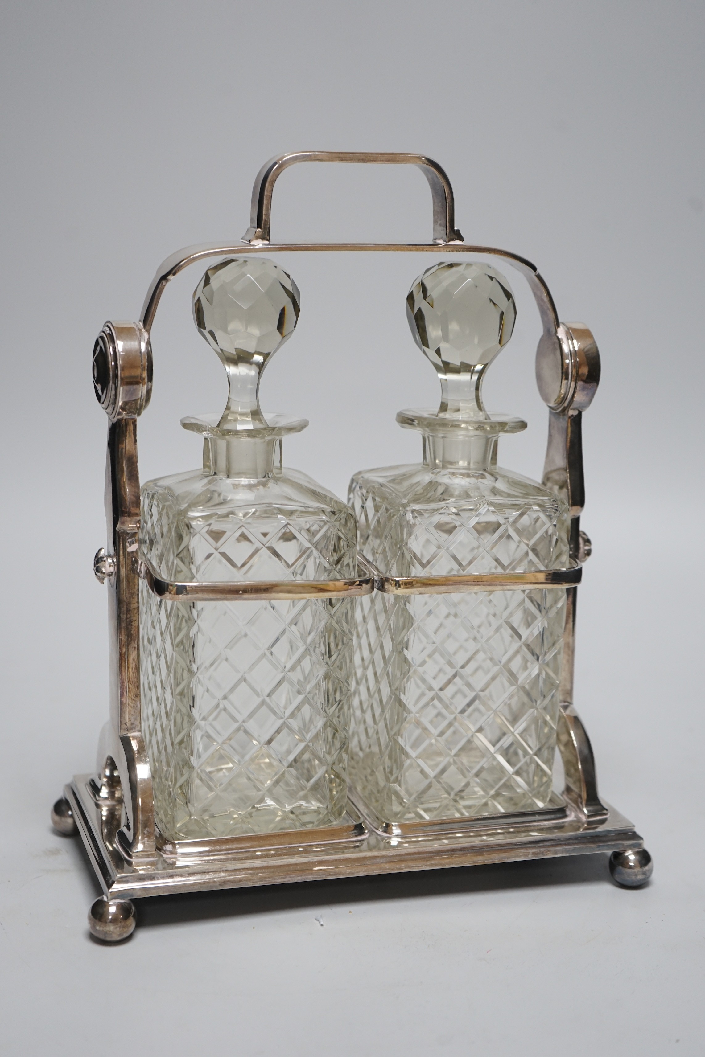 A plated tantalus with two bottles